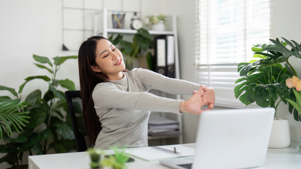women at desk stretching her wrist