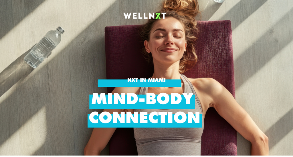 a female presenting person with long hair laying on a yoga mat with eyes closed. A water bottle is in the background on the ground.